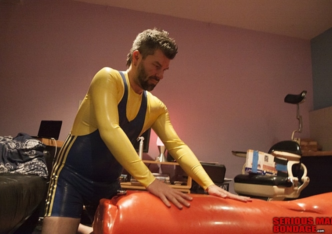 A137_MALEBONDAGE_AllPumpedUp-RickChristianAndAnotherGuy-ChristianInOrangeInflatableStudioGumBagInBasement