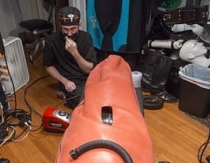 A185_MALEBONDAGE_BreatheWhileYouCan_Part2of3_ShaneDamianJames_OrangeInflatableBagLaptopAndPatientMonitor