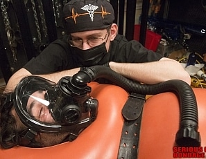 A185_MALEBONDAGE_BreatheWhileYouCan_Part2of3_ShaneDamianJames_OrangeInflatableBagLaptopAndPatientMonitor