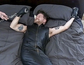 A194_MALEBONDAGE_TheAfternoonNap_TreverInSleevelessLeatherSleepsackOnBindsBed_TreverBlake