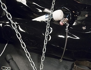 R662_MALEBONDAGE-Chain101_Wired4Fun_BootedRay_Mark_InRubberOnBondageTableWithHeadBoxFrontRoom